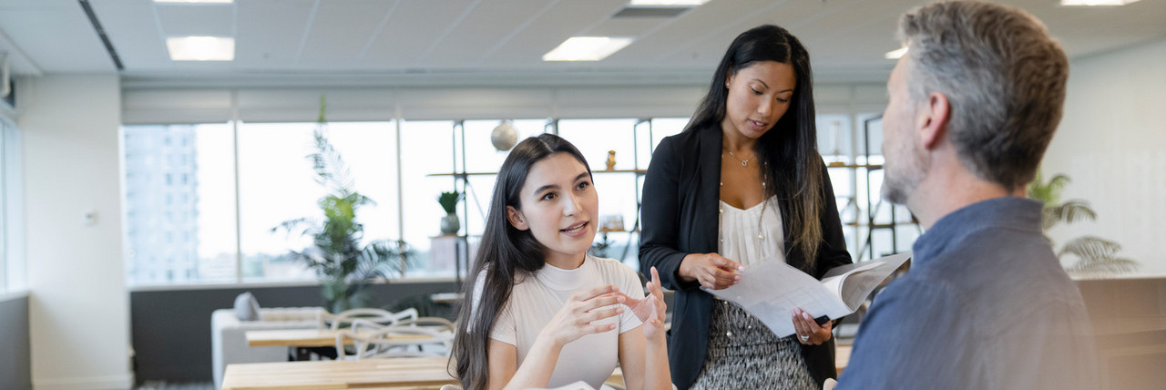 Foto: selbstbewusste Auszubildende erkl&auml;rt Kollegen den Plan.