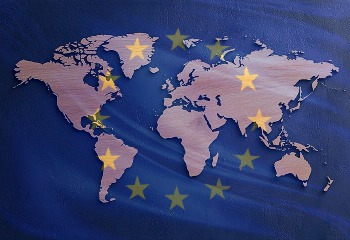 Auf dem Bild ist die Weltkarte grafisch dargestellt. &Uuml;ber ihr schein die europ&auml;ische Flagge leicht durch.